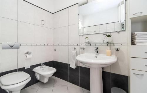 een witte badkamer met een toilet en een wastafel bij 3 Bedroom Beautiful Apartment In Sutivan in Sutivan