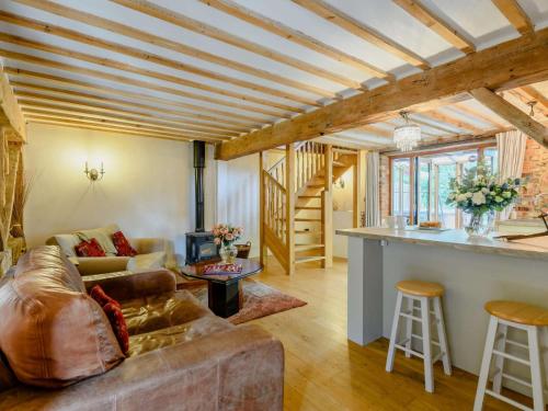 a living room with a couch and a table at 16th Century Cartlodge with private hot tub in Diss