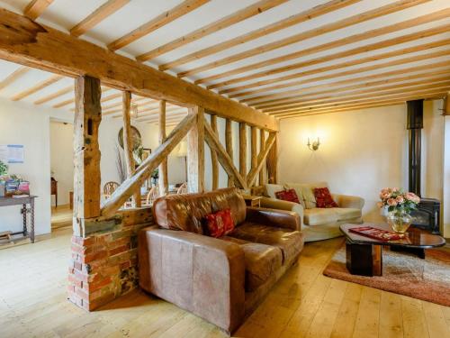 a living room with a couch and a brick fireplace at 16th Century Cartlodge with private hot tub in Diss