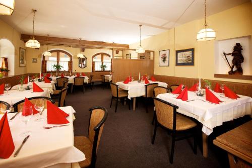 un restaurante con mesas con servilletas rojas. en Hotel Grafenwirt, en Wagrain