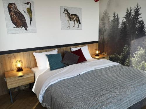 a bedroom with a bed with pillows and a wolf poster at Jaworzynka 89 in Jaworzynka