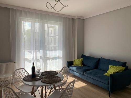 Platinum De Lux Apartament في ستارغارد: غرفة معيشة مع أريكة زرقاء وطاولة