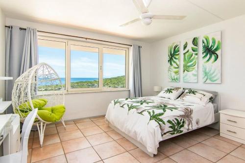a bedroom with a swinging bed and a window at The Beach Penthouse in Willemstad