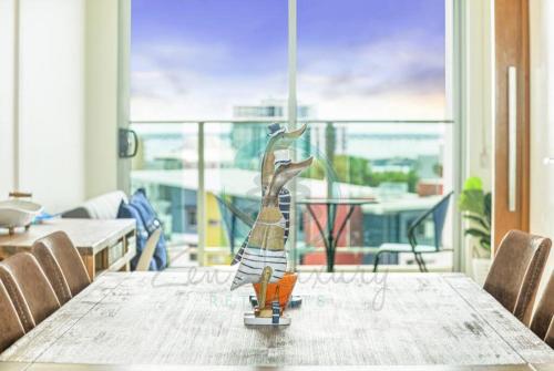 a wooden figurine of a woman sitting on a table at ZEN SEA BREEZE - Darwin's Premier Family Apt in Darwin