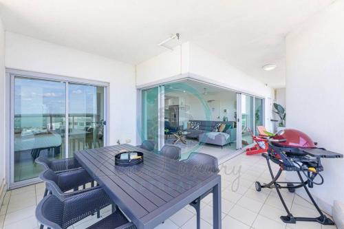 a dining room with a table and chairs at ZEN SEA BREEZE - Darwin's Premier Family Apt in Darwin