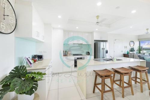 a kitchen with a large clock on the wall at ZEN SEA BREEZE - Darwin's Premier Family Apt in Darwin
