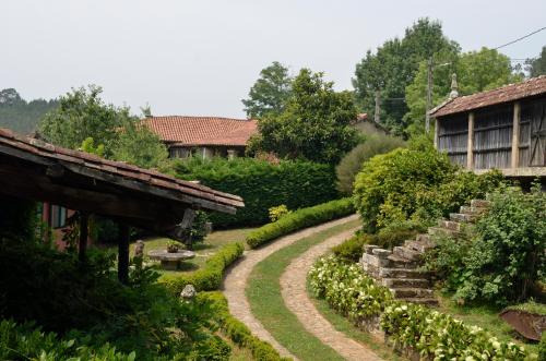 a garden with a winding path next to a house at Casa Dos Cregos in Bascuas