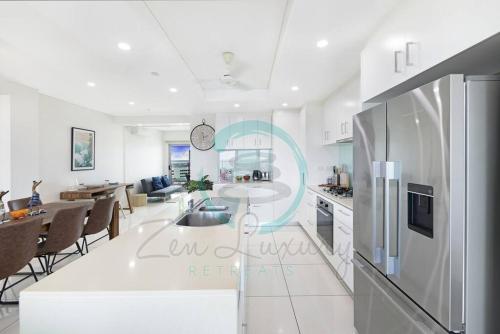 a kitchen and living room with a table and a dining room at ZEN SEA BREEZE - Darwin's Premier Family Apt in Darwin