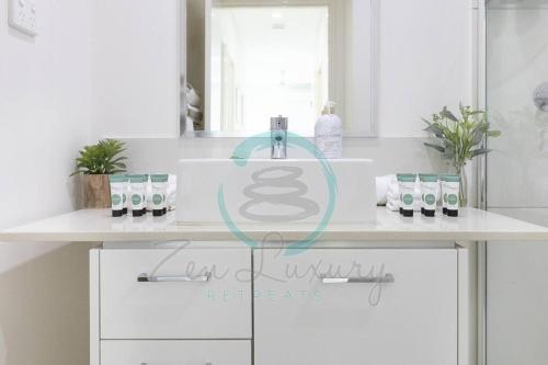 a white bathroom with a sink and a counter at ZEN SEA BREEZE - Darwin's Premier Family Apt in Darwin