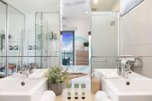 a bathroom with two sinks and a mirror at ZEN SEA BREEZE - Darwin's Premier Family Apt in Darwin