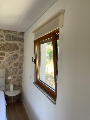 a room with a window and a small table at Casa do capitão A casa ideal para férias no Gerês in Vieira do Minho