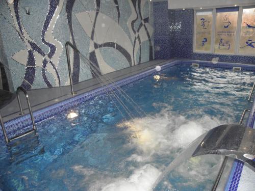 a jacuzzi tub with water coming out of it at Fifth Ocean SPA Hotel in Truskavets