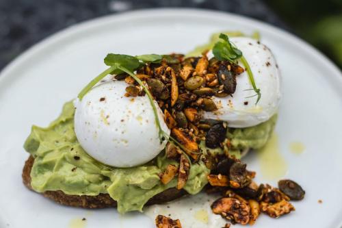 a white plate with a sandwich with eggs and nuts at Das Aunhamer Suite & Spa Hotel in Bad Griesbach