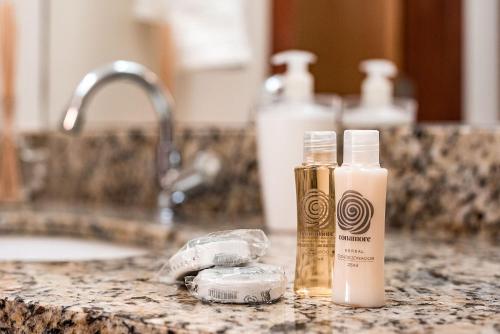 a bathroom counter with a bottle of soap and a sink at Studio c Localização Exclusiva em Jardim da Penha in Vitória