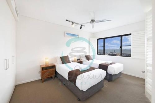 a bedroom with two beds and a window at ZEN PARADISE - 2-BR Waterfront Ocean View Retreat in Darwin
