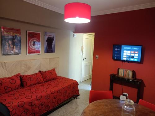 sala de estar con sofá rojo y mesa en Departamento Legarra Mar en Miramar