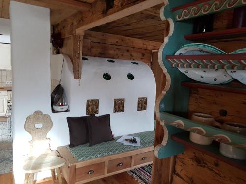 Zimmer mit einem Stuhl und einem Regal mit Keramik in der Unterkunft Haus Edelweiss - Ferienhaus in Spiss