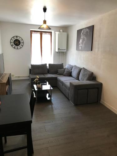 a living room with a couch and a table at Au Faubourg in Saint-Claude