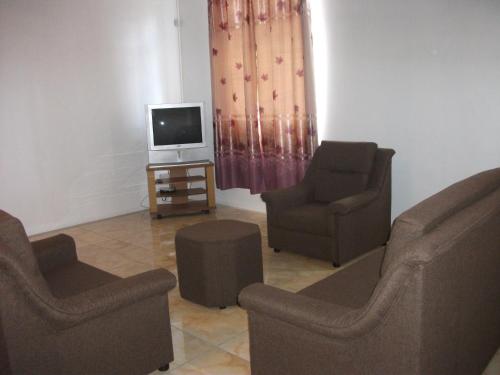 a living room with two chairs and a television at La Dorade in Trou aux Biches