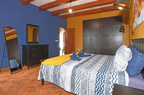 a bedroom with a bed with two blue stuffed animals on it at Villa Mica in Tijarafe