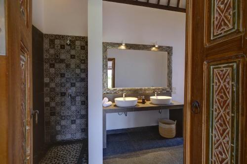 a bathroom with two sinks and a mirror at Wide Sands Beach Retreat in Pulukan