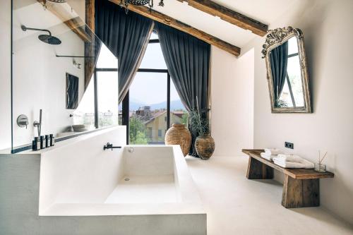 a bathroom with a white tub and a large window at To Be Social House in Fethiye