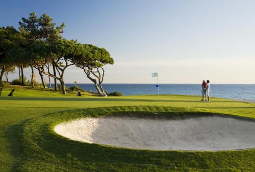 a couple of people standing on a golf course at Ria Park Hotel & Spa in Vale do Lobo