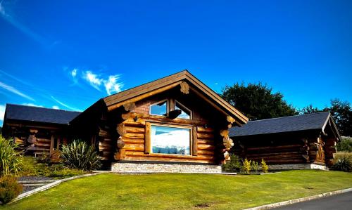 a log cabin with a large window in a yard at The Log Cabins at The Vu in Bathgate