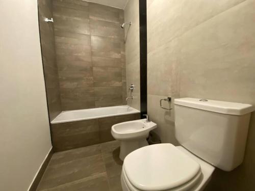 een badkamer met een toilet en een bad bij La Escondida Salta 7 in General Alvarado