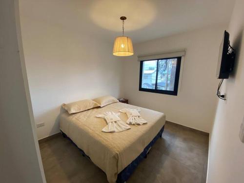 een slaapkamer met een bed met twee handdoeken erop bij La Escondida Salta 7 in General Alvarado