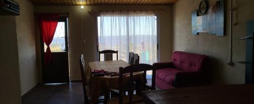 a living room with a table and a purple couch at Afecto in San Gregorio de Polanco