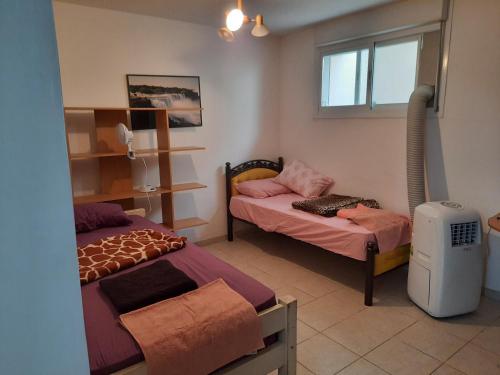 a room with two beds and a window at Best Home Jerusalem Holy Land Close to Everything Israel Gateway 4 families & individual in Jerusalem