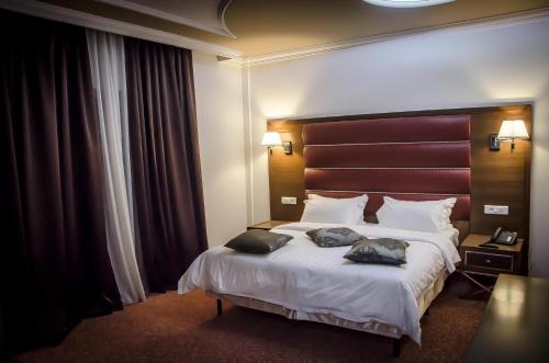 Una habitación de hotel con una cama con dos almohadas. en Hotel El Bey, en Constantina