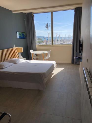 - une chambre avec un lit et une grande fenêtre dans l'établissement R.I.O. PASSIONS, à Toulon