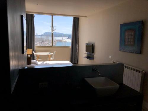 une salle de bain avec un lavabo et une grande fenêtre dans l'établissement R.I.O. PASSIONS, à Toulon
