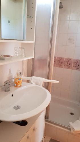 a white bathroom with a sink and a shower at Ferienwohnung Mönch in Christes