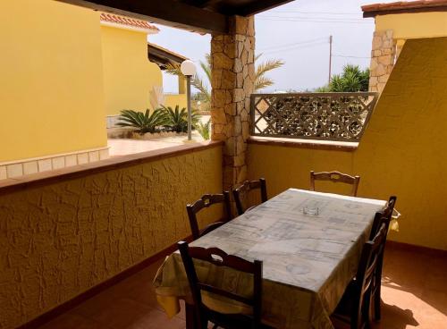 uma mesa e cadeiras na varanda de uma casa em Residence Il Melograno em Lampedusa