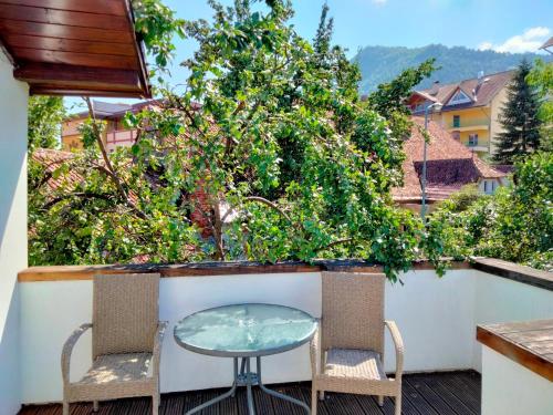 einen Tisch und zwei Stühle auf dem Balkon in der Unterkunft Casa Scheiana in Braşov