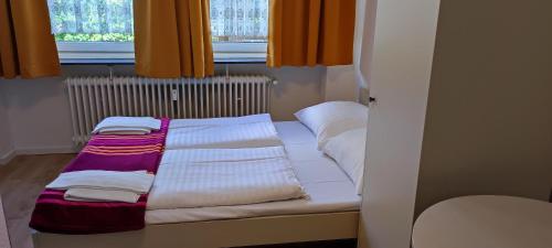 a small bed in a room with two pillows on it at The Hostel in Hamburg