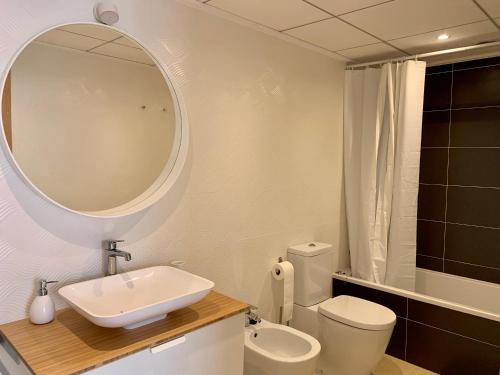 ein Badezimmer mit einem Waschbecken, einem WC und einem Spiegel in der Unterkunft Precioso apartamento primera línea de playa in Águilas