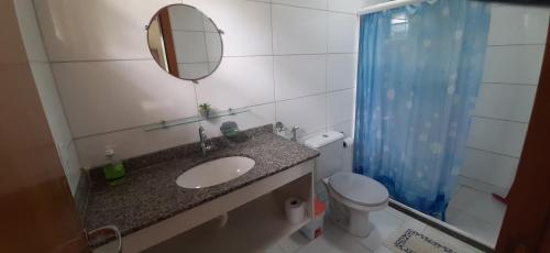 y baño con lavabo, espejo y aseo. en Residence Cotê d' Azur, en Imbassai