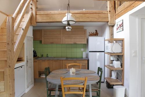une cuisine avec une table, des chaises et un réfrigérateur dans l'établissement Gîte de l'Abbatiale,3 étoiles, dans une grange du XVIIIème ,1 à 6 personnes, à Ebersmunster