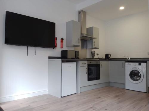 a kitchen with white appliances and a tv on the wall at City Apartments Charles Street in Hull