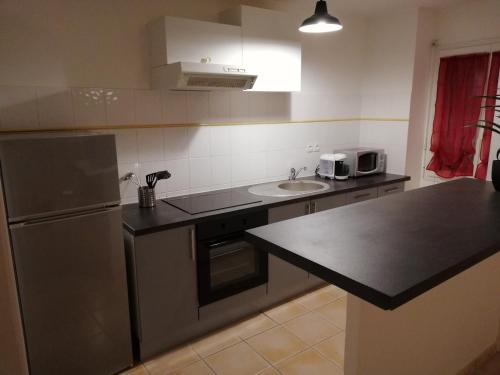 La cuisine est équipée d'un réfrigérateur et d'un évier. dans l'établissement T2 en résidence avec piscine proche île madame et océan, à Le Port-des-Barques