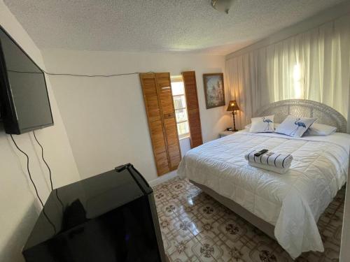 a bedroom with a bed and a flat screen tv at Habitacion Centrica Calle 8 Miami (2) in Miami