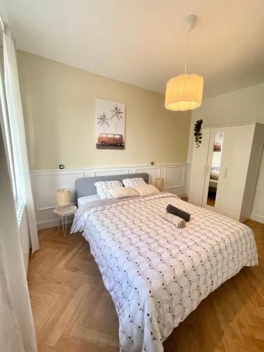 a bedroom with a large bed with a white comforter at JungleClassic en plein cœur de Mulhouse in Mulhouse