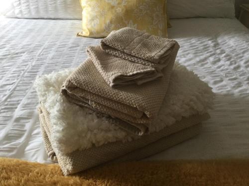 a pile of towels sitting on top of a bed at Nether Dallachy Farmhouse in Banff
