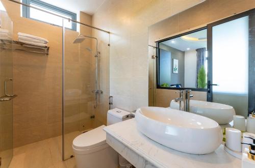 a bathroom with a sink and a toilet and a shower at Villa Charming Hoi An in Hoi An