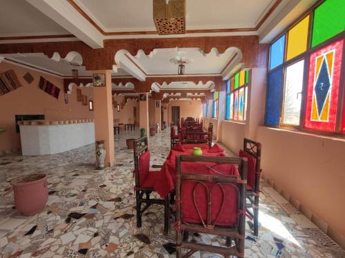 un restaurant avec des tables et des chaises rouges et des vitraux dans l'établissement Auberge Restaurant Targa Taliouine, à Taliouine