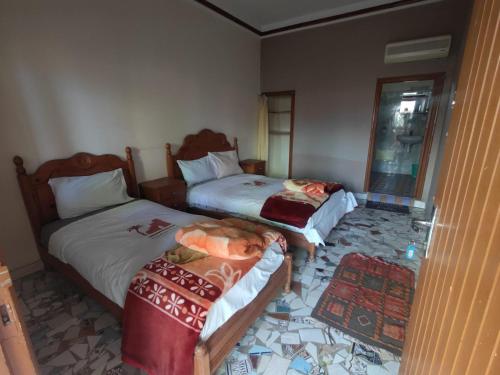 um quarto de hotel com duas camas e um espelho em Auberge Restaurant Targa Taliouine em Taliouine